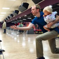 Ted Hawkes bowling with baby